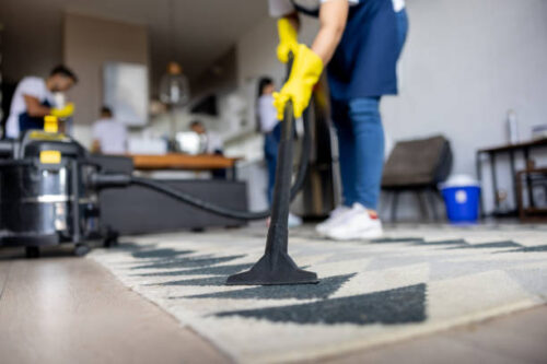 istockphoto-1417833187-612x612 Close-up on a professional cleaner vacuuming a carpet while working at an apartment - housework concepts